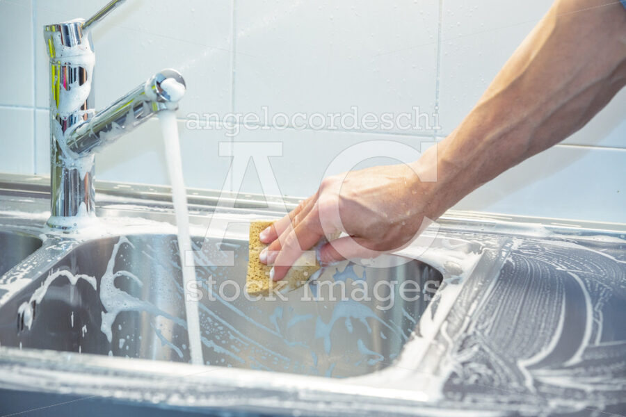 A Man Cleaning And Washing The Sink In The Kitchen. One Arm, One Angelo Cordeschi