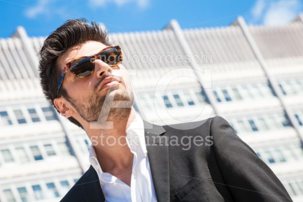 Confident business handsome man with sunglasses standing outdoor. - Angelo Cordeschi