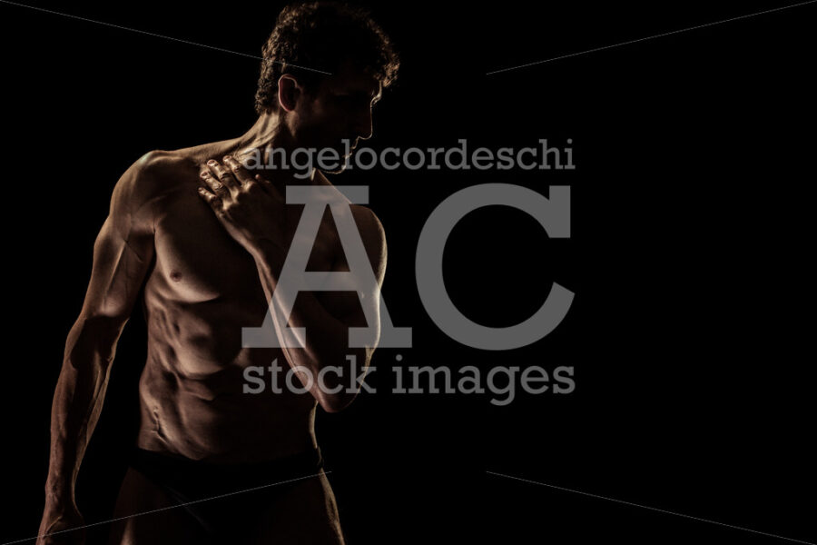 Muscular man isolated in the dark shade. Athletic body. - Angelo Cordeschi